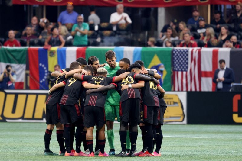 Atlanta United goalkeeper Alec Kann (center, in green) and teammates huddle up before their match against the Columbus Crew on Saturday, July 24, 2021, at Mercedes Benz Stadium in Atlanta. (Jason Getz/For the AJC)