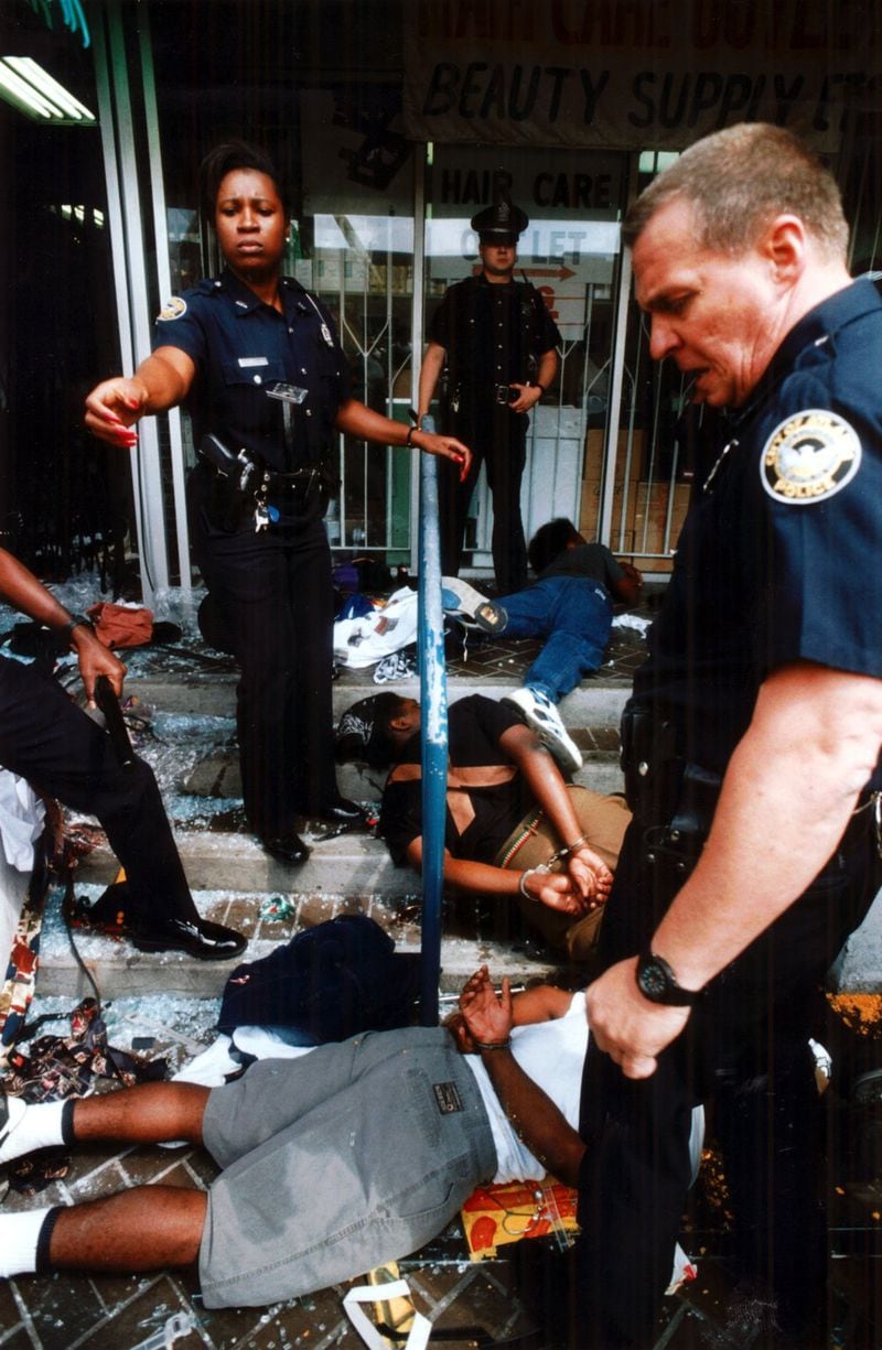 April 30, 1992 — Atlanta police and SWAT team members arrest looters at a clothing store at Little Five Points during a riot in reaction to the Rodney King verdict. (W.A. Bridges Jr. / AJC 1992 file photo)