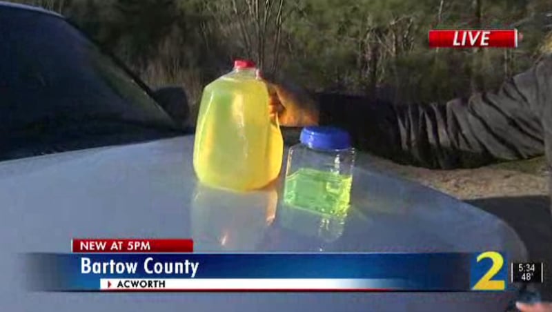 The jug on the left is the tainted fuel, which also contains visible residue and debris inside the liquid. The container on the right is diesel fuel that meets state regulations.