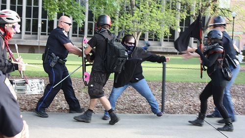 An anti-fascist counter protester clashes with Auburn police before Tuesday's appearance by white supremacist Richard Spencer. Three people were arrested for disorderly conduct.