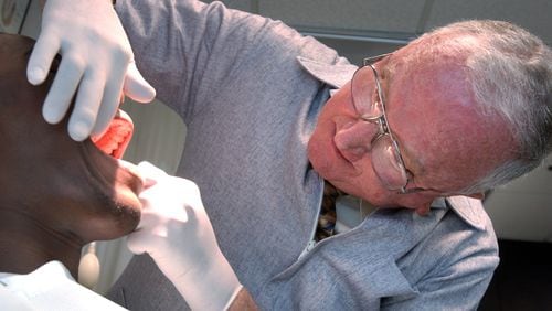 An August 2004 photo of Georgia Tech team doctor Aaron King taking a dental impression of then-freshman Calvin Johnson, one of thousands that King made for custom mouthguards over his nearly 60 years of service to the Yellow Jackets. (AJC file photo by Rich Addicks)