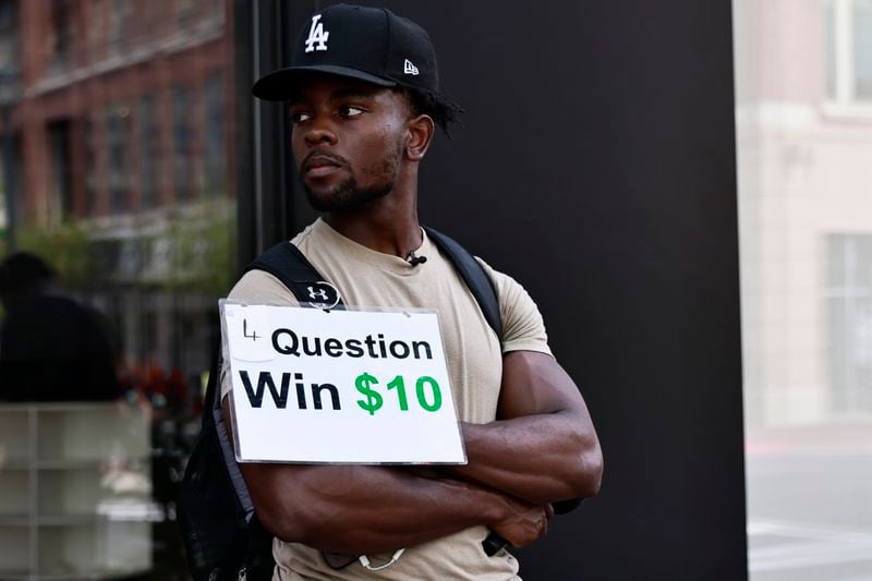 TikTok star Leon Ondieki waits to interview people for his trivia game on Friday, July 22, 2022. (Natrice Miller/natrice.miller@ajc.com)