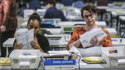 Elections Coordinator, Shantell Black (left) and Elections Deputy Director, Kristi Royston open and scan absentee ballots on Wednesday morning, Nov. 7, 2018 at the Gwinnett County Voter Registration and Elections Office in Lawrenceville. JOHN SPINK/JSPINK@AJC.COM