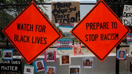 These sgns were placed on the fence in front of the White House in Washington during racial inequality protests last summer. (Yuri Gripas/Abaca Press/TNS)