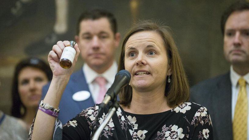 Shannon Cloud, a parent of a child who suffers from seizures, holds up a bottle of THC oil during a press conference earlier this year at the Georgia Capitol in Atlanta. The Georgia Senate Friday approved a bill that would allow the distribution and sale of medical marijuana in Georgia. (ALYSSA POINTER/ALYSSA.POINTER@AJC.COM)