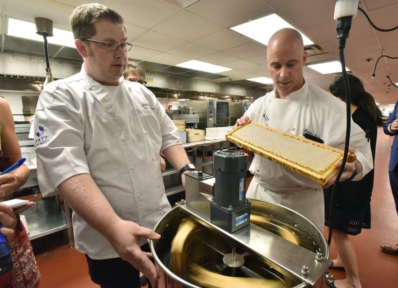 Thomas McKeown (left), executive chef, operates a honey extractor as James Gallo (right), pastry chef, holds a hive frame at Hyatt Regency Atlanta. McKeown oversees four hives at the Hyatt. HYOSUB SHIN / HYOSUB.SHIN@AJC.COM