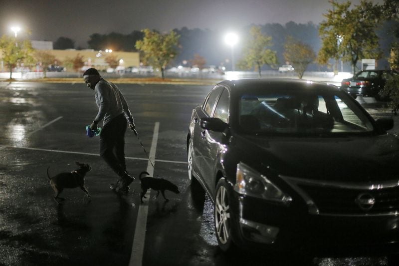 Krystina Brown walks her dogs before dawn each day.  A  veteran, Brown is temporarily homeless, and said she sleeps in her car with her dogs, Dinero and Karat.   BOB ANDRES / BANDRES@AJC.COM