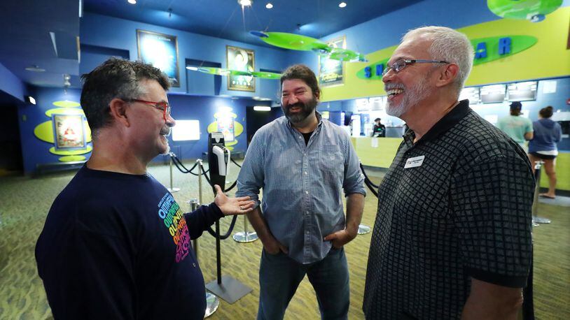080822 Atlanta: Jim Farmer, director of the Out on Film Festival (left), and his husband Craig Hardesty (right), board chair, are greeted by Josh Rosenfield at the Landmark Midtown Art Cinema during a screening there. Curtis Compton / Curtis Compton@ajc.com