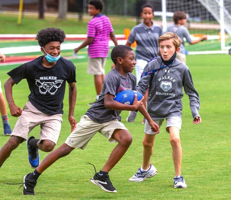 Sixth grader David Griggs runs with the football during a break from class at The Walker School in Marietta Friday, August 20, 2021.STEVE SCHAEFER FOR THE ATLANTA JOURNAL-CONSTITUTION
