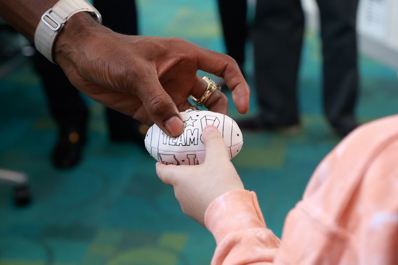NFL Hall of Famer and former Georgia Tech player Calvin Johnson hands a signed football to Colton Hall, 9, during a visit to Egleston Children’s Hospital in Atlanta on Friday, September 1, 2023. (Natrice Miller/ Natrice.miller@ajc.com) 