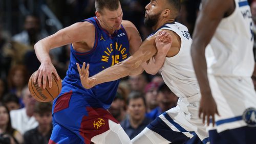 Denver Nuggets center Nikola Jokic, left, drives to the basket as Minnesota Timberwolves center Rudy Gobert defends in the second half of Game 1 of an NBA basketball second-round playoff series Saturday, May 4, 2024, in Denver. (AP Photo/David Zalubowski)