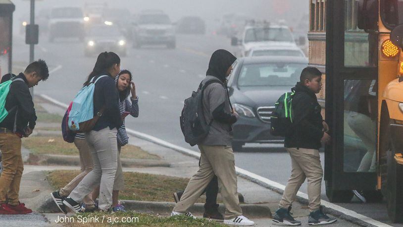 School children deal with fog getting on the bus onSchool children get on the bus on S. Cobb Dr. near Pat Mell Road in the fog