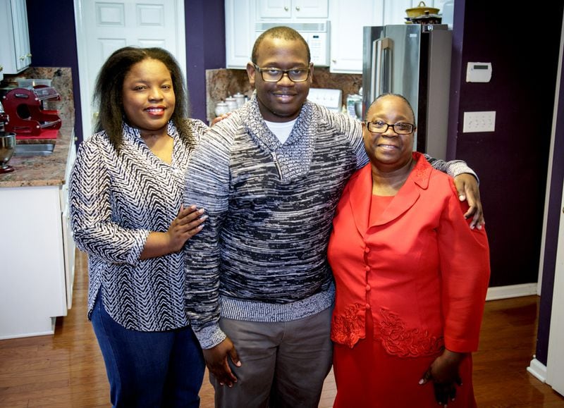 Duane Carver stands with this sister Chriscynthia Young (L) and his mother Sosa Carter (R) in their Stockbridge, GA home Wednesday,  December 14, 2016. All three who at one time lived in poverty, now have college degrees and live together in Stockbridge. STEVE SCHAEFER / SPECIAL TO THE AJC