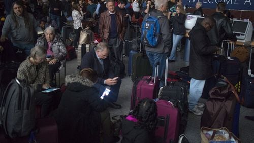 Passengers wait in a darkened terminal at Hartsfield-Jackson International Airport Sunday, Dec. 17, after a power failure shut down the world’s busiest airport. STEVE SCHAEFER / SPECIAL TO THE AJC