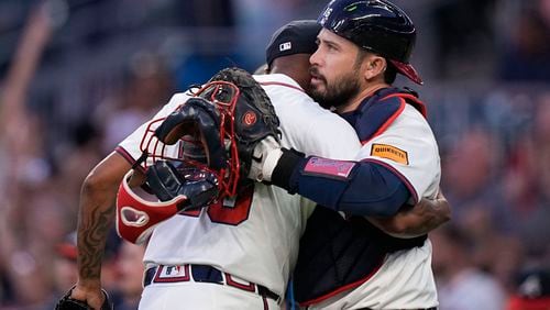 Atlanta Braves pitcher Raisel Iglesias (26) and Atlanta Braves catcher Travis d'Arnaud (16) celebrate after a win against the San Diego Padres, Monday, May 20, 2024, in Atlanta. (AP Photo/Brynn Anderson)