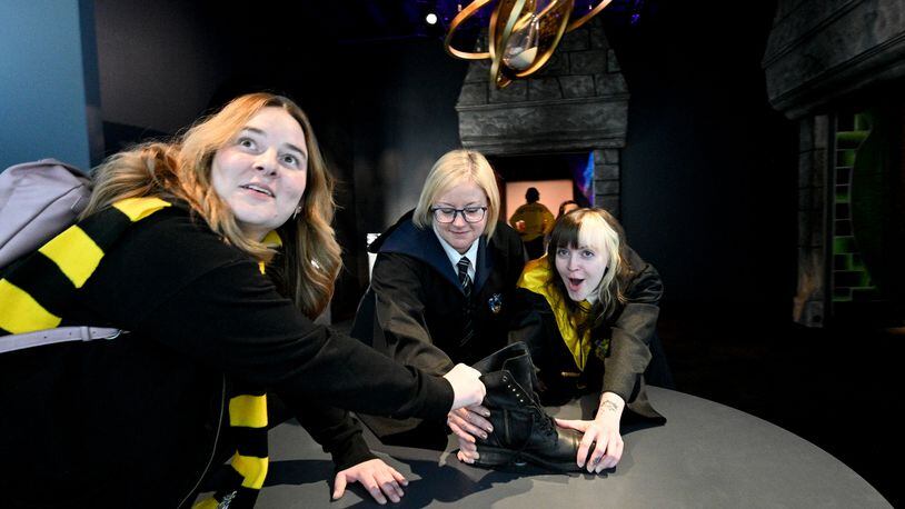 October 21, 2022 Atlanta - Harry Potter fans (from left) Alyssa Burgess, Jessica Simon and her daughter Sunshine Patterson react as they enjoy authentic props, costumes, and interactive technology at 200 Peachtree Street in downtown Atlanta on Friday, October 21, 2022. Created by Atlanta-based Imagine Exhibitions, “Harry Potter: The Exhibition” will take place at 200 Peachtree St. where Macy’s used to be located. (Hyosub Shin / Hyosub.Shin@ajc.com)