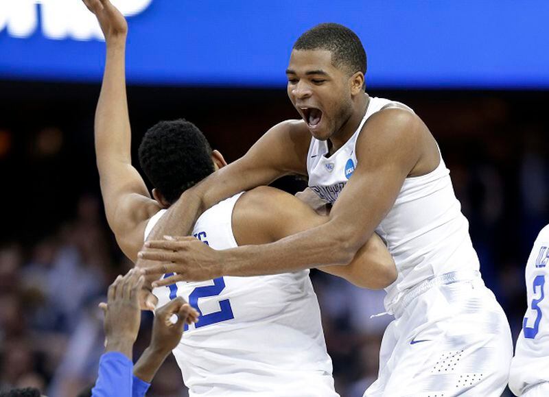 Kentucky's Aaron Harrison, right, leaps on Karl-Anthony Towns (12) after the team's 68-66 win over Notre Dame in a college basketball game in the NCAA men's tournament regional finals, Saturday, March 28, 2015, in Cleveland. Kentucky advances to the Final Four with a 38-0 record. (AP Photo/Tony Dejak)