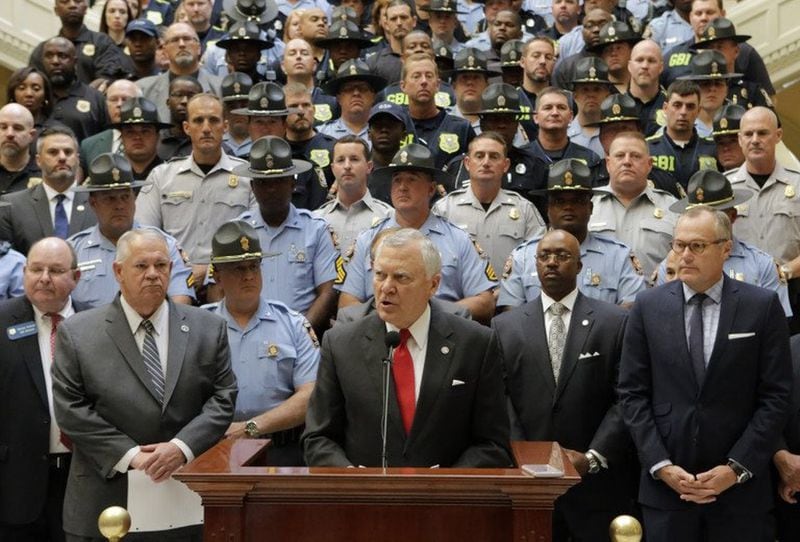Gov. Nathan Deal last year with a law enforcement backdrop announcing he wanted to give a 20 percent pay hike to state officers, a move that has a domino effect with other departments. Photo by Bob Andres