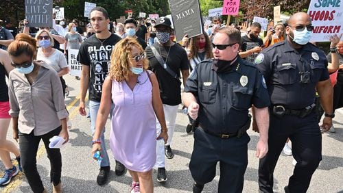 Congresswoman Lucy McBath (left) and Roswell Police Chief James Conroy talk as they march with peaceful protesters during a Solidarity March in downtown Roswell on Saturday. (Hyosub Shin / Hyosub.Shin@ajc.com)