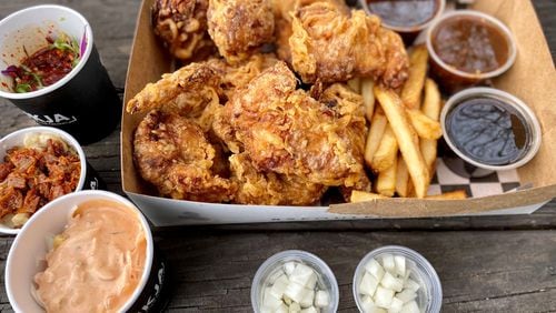 This takeout order from Mukja Korean Fried Chicken includes a whole fried chicken with sauces, fries, pickled radish and sides. Wendell Brock for The Atlanta Journal-Constitution