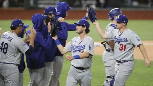 Los Angeles Dodgers center fielder Cody Bellinger (center) and Los Angeles Dodgers left fielder Joc Pederson (31) celebrate with the team after their victory in Game 5 Friday, Oct. 16, 2020, for the best-of-seven National League Championship Series at Globe Life Field in Arlington, Texas..  (Curtis Compton / Curtis.Compton@ajc.com)