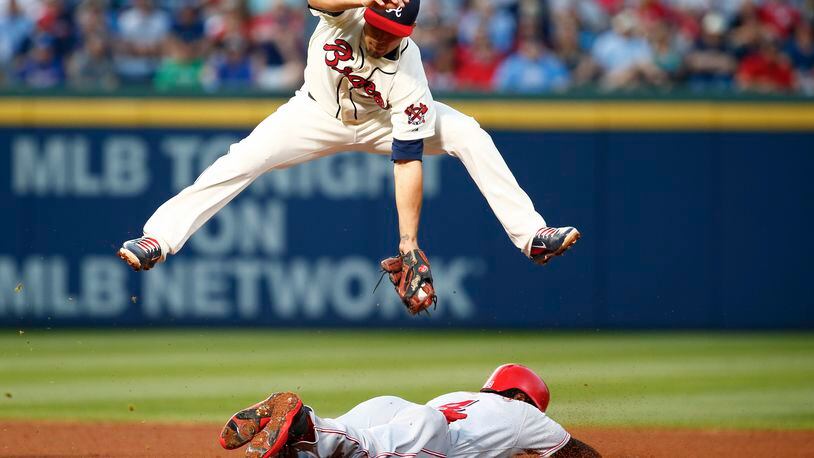 Cincinnati Reds' Brandon Phillips slides safely under Atlanta Braves second baseman Jace Peterson at second during the fourth inning of a baseball game Saturday, May 2, 2015 in Atlanta. (AP Photo/Kevin Liles)