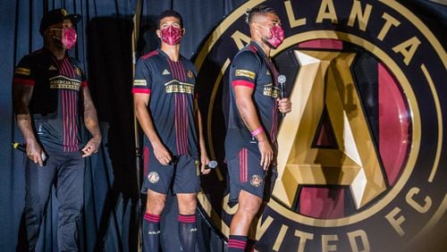 Atlanta United celebrates the beginning of their 5th season with Jay-Z, from left, Miles Robinson and Josef Martinez unveiling the 2021 team uniforms Friday, Feb 26, 2021 during a drive-in at the Home Depot Backyard.  (Jenni Girtman for The Atlanta Journal-Constitution)