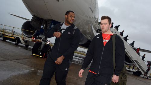 Georgia defensive end Jonathan Ledbetter (13) and quarterback Jake Fromm (11) walk away from the plane as the Bulldogs arrived Thursday, Dec. 27, 2018, at Louis Armstrong International Airport in New Orleans.