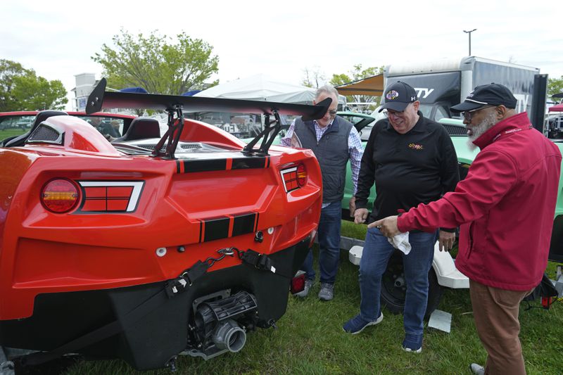 Former Maryland Gov. Larry Hogan, second from right, and Ronald Cole, right, of Annapolis, Md., talk while looking at a JetCar at the Bridge Boat Show in Stevensville, Md., Friday, April 12, 2024, as he campaigns for the U.S. Senate. (AP Photo/Susan Walsh)