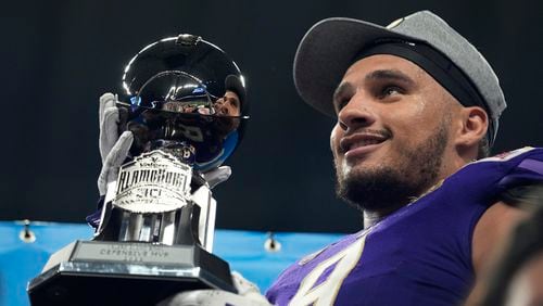 Washington defensive lineman Bralen Trice holds his defensive MVP trophy after defeating Texas in the Alamo Bowl NCAA college football game in San Antonio, Thursday, Dec. 29, 2022.  The Falcons picked Trice in the third round of the NFL draft Friday night. (AP Photo/Eric Gay, File)