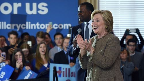 Democratic presidential candidate Hillary Clinton speaks as Atlanta Mayor Kasim Reed (right) supports her at a February event in Coca-Cola’s hometown. HYOSUB SHIN / HSHIN@AJC.COM