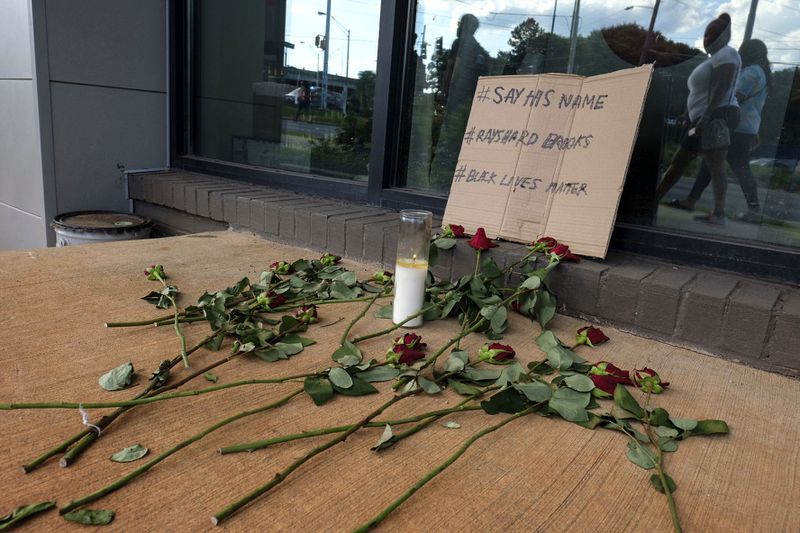People are leaving flowers at a memorial down the street from Wendy's where Rayshard Brooks, a 27-year-old black man,  was shot and killed by Atlanta police Friday evening during a struggle with police in the drive-thru line.    Ben Gray for the Atlanta Journal Constitution