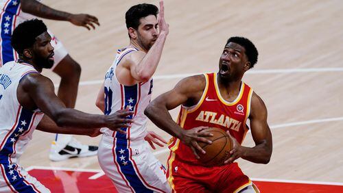 Atlanta Hawks forward Solomon Hill (18) is defended by Philadelphia 76ers guard Furkan Korkmaz (30) and center Joel Embiid (21) during the second half of Game 3 of a second-round NBA basketball playoff series Friday, June 11, 2021, in Atlanta. (AP Photo/John Bazemore)