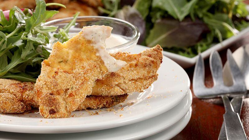 Parmesan chicken tenders, adapted from Diana Henry's book "Simple," are served on mixed greens with yogurt Caesar salad dressing. (Michael Tercha/Chicago Tribune/TNS)