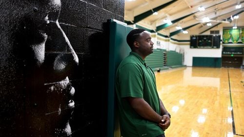 Athletic Director Willie McGee stands next to a mural of former high school teamate and childhood friend LeBron James in the gym at St. Vincent-St. Mary High School in Akron, Ohio. (Wally Skalij/Los Angeles Times/TNS)