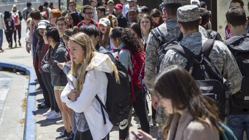 University of Georgia students wait for buses at the Tate Student Center bus stop on the University of Georgia campus in Athens, Georgia, on Tuesday, April 17, 2018. (REANN HUBER/REANN.HUBER@AJC.COM)