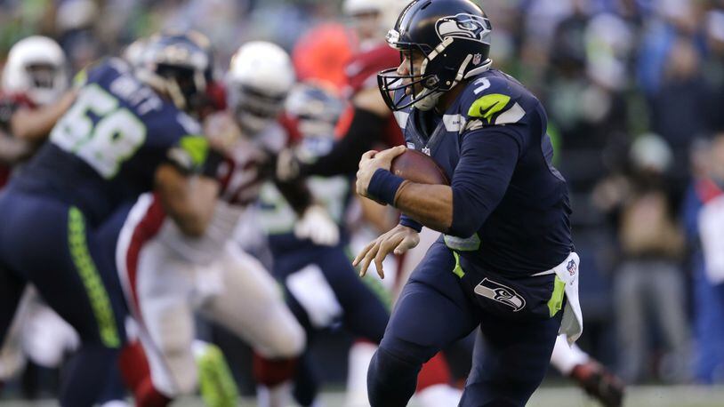 Seattle Seahawks quarterback Russell Wilson carries the ball against the Arizona Cardinals in the first half of an NFL football game, Saturday, Dec. 24, 2016, in Seattle. (AP Photo/John Froschauer)