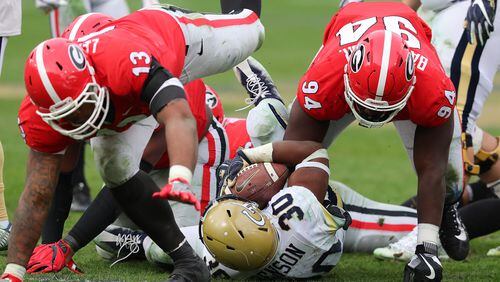 Georgia defenders Jonathan Ledbetter (left) and Michael Barnett level Georgia Tech running back KirVonte Benson during the second half Saturday at Bobby Dodd Stadium. The Bulldogs will need a strong defensive effort to beat Auburn in the SEC championship game.