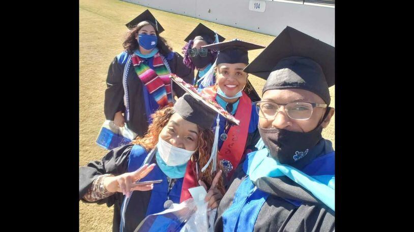 Ashley Jones, in the center, smiling, celebrates with classmates after receiving their degrees from the University of West Georgia in December 2020. Jones and those classmates transferred from Argosy University, which abruptly closed in March 2019. PHOTO CONTRIBUTED.