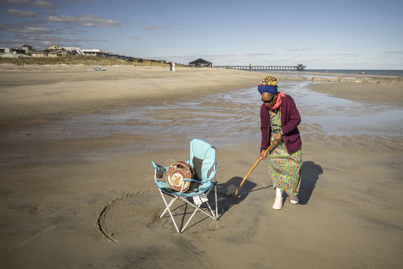 Julia Pearce, who's running for may of Tybee Island, draws a full circle around her beach chair as an invitation for friends to join her spot on the beach. Pearce is a well-known activist for the island's Black history, and she said she draws a circle as an acknowledgment to her community and her ancestors. (AJC Photo/Stephen B. Morton)