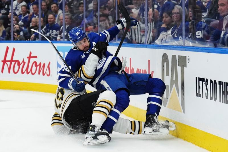 Boston Bruins' Charlie McAvoy, bottom, takes down Toronto Maple Leafs' Auston Matthews during the second period of action in Game 3 of an NHL hockey Stanley Cup first-round playoff series in Toronto on Wednesday, April 24, 2024. (Nathan Denette/The Canadian Press via AP)