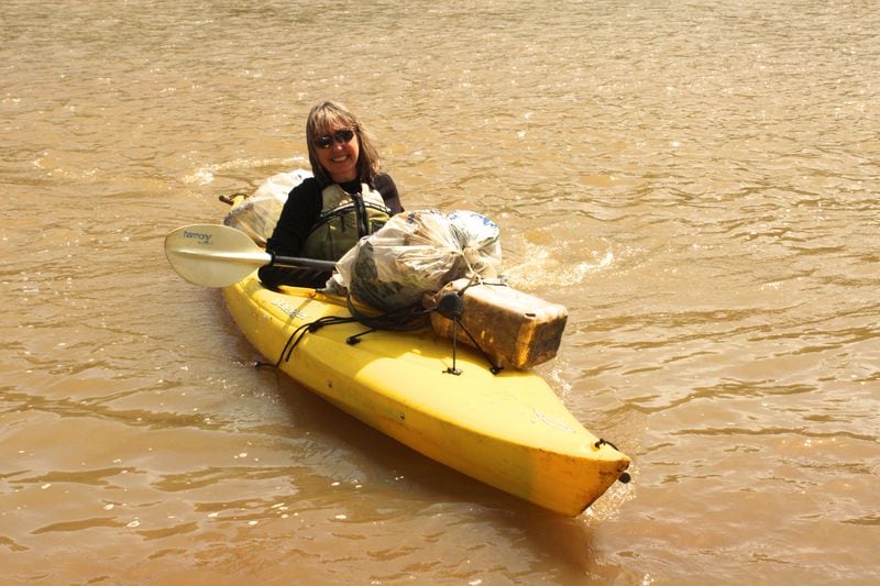 In a photo from 2014 Sally Bethea, founding director of the Chattahoochee Riverkeeper, collects trash during a Sweep the Hooch cleanup, an annual event that draws more than a thousand volunteers to remove garbage from the river. Photo: Riverkeeper
