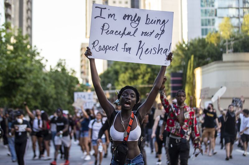 A woman chants as she holds a sign referring to her peaceful protest with respect for Atlanta’s Mayor Keisha Lance-Bottoms during a march down Spring Street NW during the third day of protest in Atlanta May 31, 2020. A group of at least 100 protesters peacefully walked from Centennial Olympic Park to the 17th street bridge in Midtown Atlanta. ALYSSA POINTER / ALYSSA.POINTER@AJC.COM