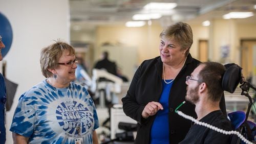 Sarah Morrison (center) talks with Katie McRae, an occupational therapist, and Brett Greenhill, a patient of the Spinal Cord Injury Rehabilitation program at Shepherd Center. Morrison takes over as Shepherd’s CEO and president on Feb. 20. LOUIE FAVORITE