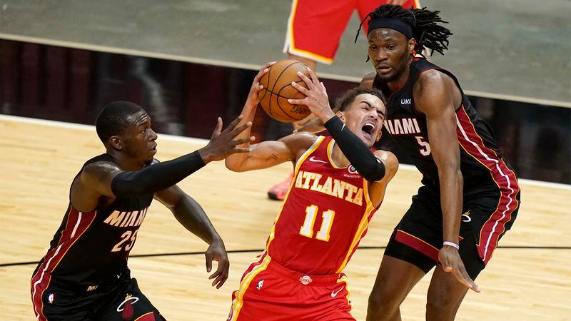 Atlanta Hawks guard Trae Young (11) drives to the basket as Miami Heat guard Kendrick Nunn (25) and forward Precious Achiuwa (5) defend during the first half Sunday, Feb. 28, 2021, in Miami. (Lynne Sladky/AP)