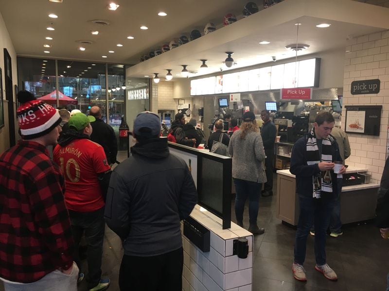 Atlanta United fans get a last-minute warming at Chick-fil-A near the College Football Hall of Fame near the parade route.