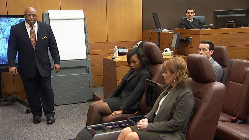 Witness Dani Jo Carter, in foreground, tells lead prosecutor Clint Rucker, at left, how Diane McIver passed the gun back to Tex on the night the Diane was shot. Carter and two other DAs are seated in a mock-up of the McIvers' SUV interior. The demonstration was part of Carter's testimony during Tex McIver's murder trial on March 19, 2018 at the Fulton County Courthouse. (Channel 2 Action News)
