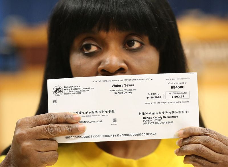 Viola Davis with her DeKalb County water bill for $503.57, demanding answers along with other local residents about excessively high water bills during a town hall meeting on Nov. 10, 2016, in Decatur. 