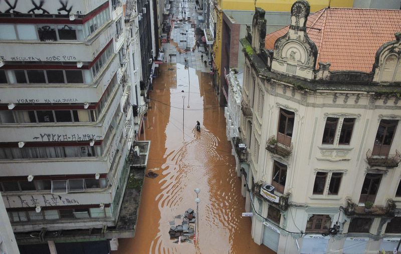 A bicyclist wades through a street flooded by heavy rains in Porto Alegre, Rio Grande do Sul state, Brazil, Saturday, May 4, 2024. (AP Photo/Carlos Macedo)