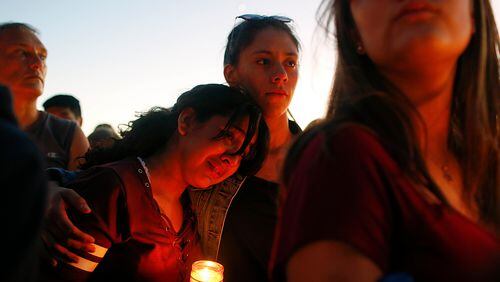 Students gather during a vigil at Pine Trails Park for the victims of the Wednesday shooting at Marjory Stoneman Douglas High School, in Parkland, Fla., Thursday, Feb. 15, 2018. Nikolas Cruz, accused of using a semi-automatic rifle in a shooting at a Florida high school, confessed to carrying out the killing and carried extra ammunition in his backpack, according to a sheriff's department report released Thursday. (AP Photo/Brynn Anderson)